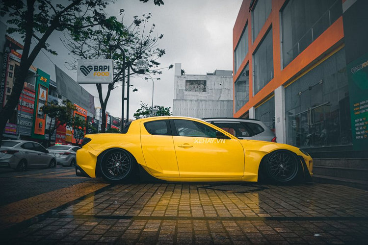 Nắp ca pô của Mazda RX-8 được thiết kế vươn dài ra phía trước, triệt tiêu lực cản gió, đồng thời giúp dáng xe thanh thoát, thể thao hơn. Mặc dù có tuổi đời hơn chục năm nhưng chiếc xe trong bài vẫn sở hữu ngoại hình long lanh với nước sơn màu vàng cá tính.