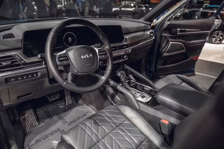 Bước vào bên trong Kia Telluride 2023, người lái sẽ bắt gặp những trang bị mới như bảng đồng hồ kỹ thuật số và màn hình thông tin giải trí nối liền với nhau, cả hai đều có kích thước 12,3 inch. Vì sự xuất hiện của màn hình cong này mà mặt táp-lô và vô lăng của xe cũng phải thay đổi thiết kế cho phù hợp.