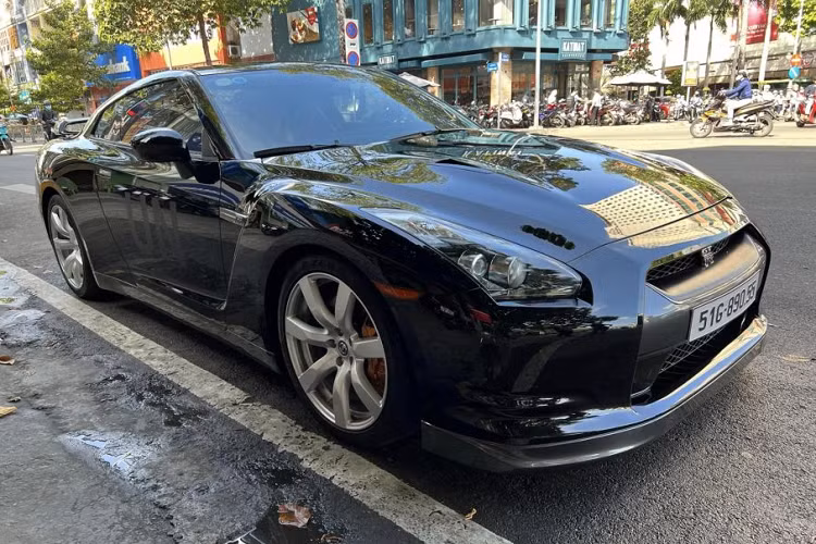 Điểm nhấn trên xe là dòng chữ UN nằm ở 2 bên cửa xe, một chi tiết đặc biệt trên tất cả các mẫu xe mà ông Vũ sở hữu. Bộ mâm xe là loại đa chấu được sơn xám, đi kèm cùm phanh màu cam. Có thể thấy, cặp ống xả của chiếc Nissan GT-R R35 của Qua Vũ đã được thay loại ống xả độ bằng chất liệu Titanium.