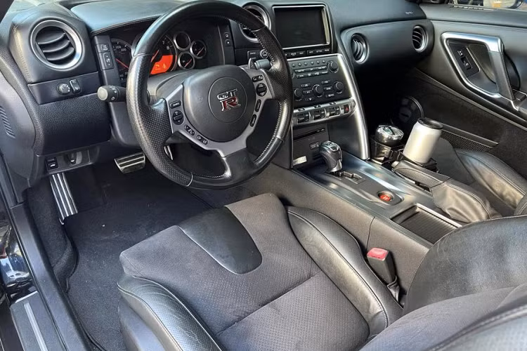 Về nội thất, khoang cabin của chiếc Nissan GT-R R35 này được thiết kế khá tối giản giúp người lái tập trung vào trải nghiệm. Xe trang bị vô lăng 3 chấu thể thao, tích hợp nhiều nút bấm. Màn hình giải trí trung tâm cảm ứng LCD kích thước 7 inch.