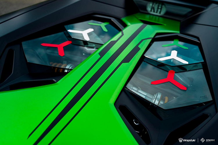 Bộ áo này vẫn lấy tông màu xanh lá làm chủ đạo nhưng có thêm màu đen tạo điểm nhấn và các viền trắng như thể hiện một đường đua, nơi mà siêu phẩm Lamborghini Essenza SCV12 có thể tung hoành hết sức mạnh 819 con ngựa của mình. Trên mỗi chiếc siêu xe đua Lamborghini Essenza SCV12 sẽ có con số 63 xuất hiện nhưng trên bộ áo của xe Lamborghini Aventador LP700-4 Roadster này lại thay bằng 68, nhiều khả năng ám chỉ quê hương của chủ xe.