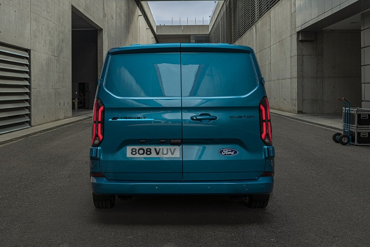Ngoài ra, Ford E-Transit Custom 2023 còn có hốc gió trung tâm khá rộng ở cản trước. Cổng sạc của xe được đặt ngay phía dưới đèn pha bên phải. Bên sườn xe, Ford E-Transit Custom 2023 được trang bị cửa trượt chỉnh điện và bộ vành hợp kim 6 chấu sơn màu xám nòng súng khá thể thao. Trong khi đó, phía sau xe xuất hiện cụm đèn hậu LED nằm dọc với tạo hình bên trong giống với dải đèn LED định vị ban ngày.