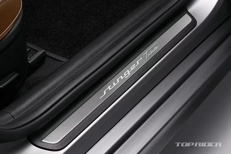 Trong khi đó, cụm điều khiển trung tâm và tapi cửa của xe được ốp giả sợi carbon nhằm mang đến vẻ thể thao. Trong tiếng Anh, từ "Stinger" có nghĩa là "vòi chích" của loài ong. Do đó, trên ghế có thêm logo hình chú ong bắp cày. Cuối cùng là ốp bậc cửa bên ghế lái khắc số thứ tự theo lựa chọn của chủ xe.