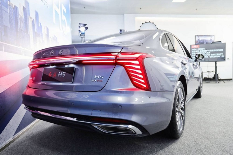 Ngoài ra, ở giữa lưới tản nhiệt còn có đường màu đỏ kéo dài lên nắp ca-pô vốn là đặc điểm nhận dạng của xe Hồng Kỳ. Bao quanh lưới tản nhiệt là nẹp mạ crôm hình chữ "U" dày dặn và đèn chào mừng. Tiếp đến là hệ thống đèn 2 tầng với dải đèn LED định vị ban ngày có thiết kế thanh mảnh và sắc sảo nằm trên cao, sát với nắp ca-pô. Trong khi đó, đèn pha chính nằm bên dưới, ở hai góc đầu xe.