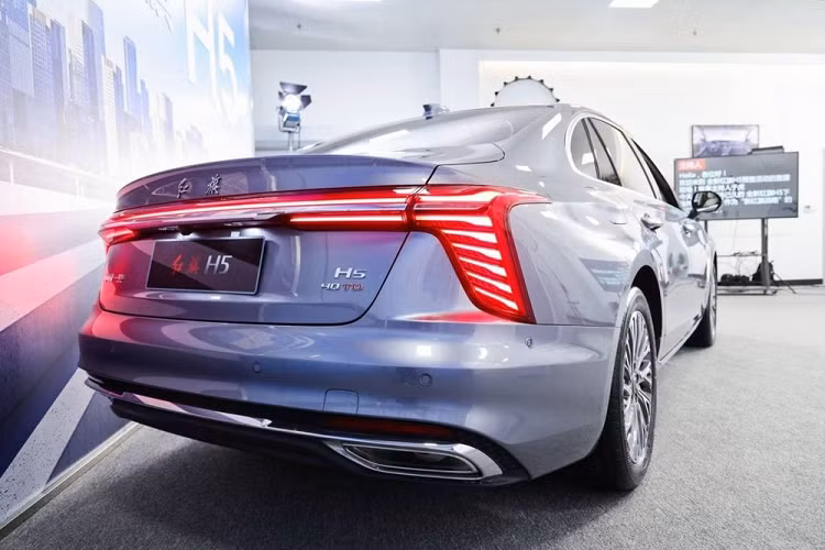 Ngoài ra, ở giữa lưới tản nhiệt còn có đường màu đỏ kéo dài lên nắp ca-pô vốn là đặc điểm nhận dạng của xe Hồng Kỳ. Bao quanh lưới tản nhiệt là nẹp mạ crôm hình chữ "U" dày dặn và đèn chào mừng. Tiếp đến là hệ thống đèn 2 tầng với dải đèn LED định vị ban ngày có thiết kế thanh mảnh và sắc sảo nằm trên cao, sát với nắp ca-pô. Trong khi đó, đèn pha chính nằm bên dưới, ở hai góc đầu xe.