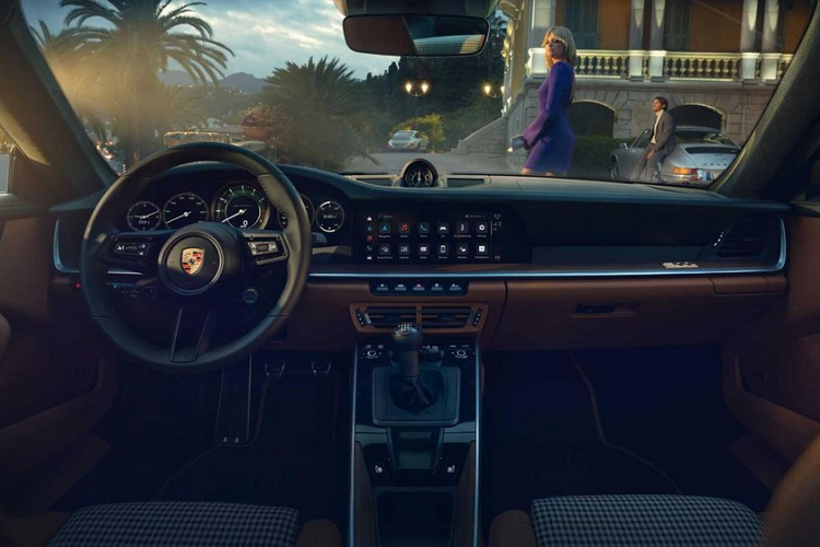 Mở cửa bước vào trong khoang lái, đập vào mắt chủ nhân của xe Porsche 911 Sport Classic 2023 là dòng chữ 911 Sport Classic trên bậc cửa như khẳng định đây là xe giới hạn Porsche 911 Sport Classic 2023, ngoài ra, ghế ngồi xe bọc da Cognac cổ điển sáng màu tương phản với họa tiết caro, các họa tiết Houndstooth cũng xuất hiện trong nội thất xe Porsche 911 Sport Classic 2023 của Cường Đô la đặt mua.