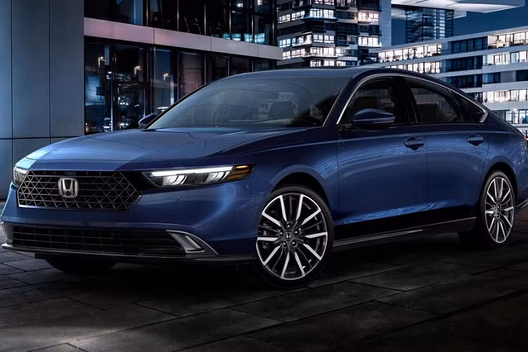 Vòng sang bên sườn, chúng ta sẽ thấy nắp ca-pô của mẫu sedan cỡ trung này có thiết kế dài hơn và sườn xe mượt mà với đường gân dập nhẹ nhàng, kéo dài từ đèn pha đến đèn hậu. Trong khi đó, thiết kế cửa sổ của xe khá giống thế hệ cũ. Đằng sau Honda Accord 2023 là cụm đèn hậu LED nằm vắt ngang đuôi xe, bao quanh bằng viền màu đen.