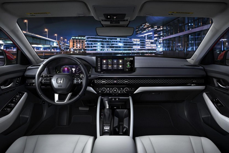 Bước vào bên trong Honda Accord 2023, người lái sẽ có cảm giác quen thuộc vì thiết kế khá giống với người anh em Civic mới. Bên trong mẫu sedan hạng D này cũng có bảng đồng hồ kỹ thuật số 10,2 inch và màn hình cảm ứng trung tâm nằm độc lập trên mặt táp-lô. Tương tự Civic, Honda Accord 2023 cũng có cửa gió điều hòa kéo dài trên mặt táp-lô, trang trí bằng tấm lưới.