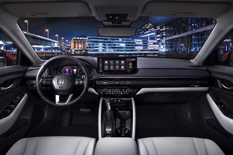 Bước vào bên trong Honda Accord 2023, người lái sẽ có cảm giác quen thuộc vì thiết kế khá giống với người anh em Civic mới. Bên trong mẫu sedan hạng D này cũng có bảng đồng hồ kỹ thuật số 10,2 inch và màn hình cảm ứng trung tâm nằm độc lập trên mặt táp-lô. Tương tự Civic, Honda Accord 2023 cũng có cửa gió điều hòa kéo dài trên mặt táp-lô, trang trí bằng tấm lưới.