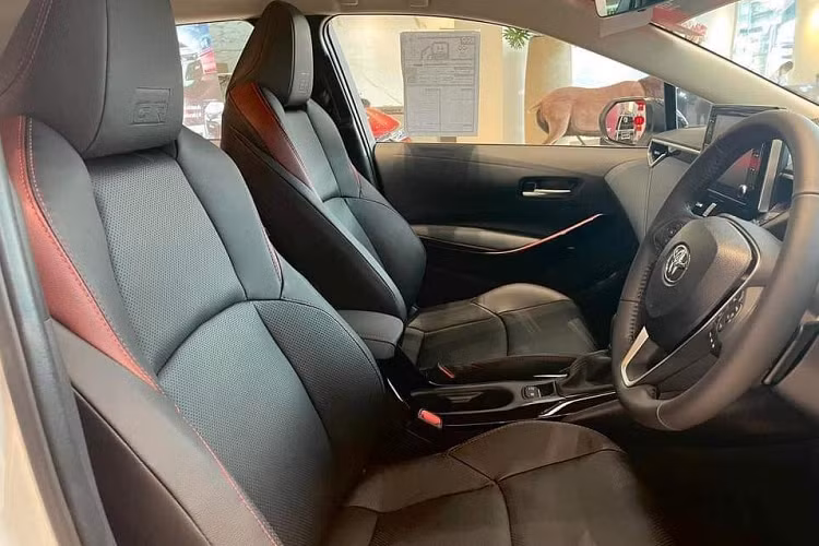 Thêm vào đó là lẫy chuyển số sau vô lăng và bệ tì tay màu đỏ trên tappi cửa. Trên tựa đầu ghế, nút bấm khởi động máy và thảm sàn đều có logo "GR". Ngoài ra, Toyota Corolla Altis GR-S 2022 ở thị trường Thái Lan còn được trang bị màn hình hiển thị thông tin kính lái HUD, hệ thống lọc không khí Nanoe và rèm che nắng ở hàng ghế sau. Cần gạt nước tự động và hệ thống cảnh báo áp suất lốp cũng là trang bị bổ sung cho phiên bản này.