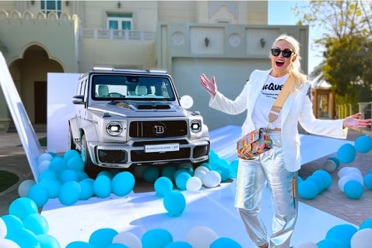 Video nhận bàn giao chiếc Brabus 800 Tiffany của Supercar Blondie đăng tải trên kênh YouTube của mình. Bắt đầu video là hình ảnh cô nàng cầm lái một chiếc Rolls-Royce Wraith màu xám tiến đến gần hộp quà lớn màu xanh lam với dải ruy băng trắng.