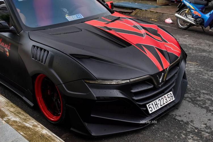 Đáng chú ý là bộ widebody này trông hầm hố với cụm đèn pha màu đỏ, mặt ca-lăng, cản trước hay nắp ca-pô có 2 cặp mắt màu đỏ đầy ma mị. Kính chiếu hậu cũng được tạo hình mới với phần ốp có tích hợp đèn viền LED. Phần vành xe được sơn màu đỏ cam, với đa chấu màu đen bóng.