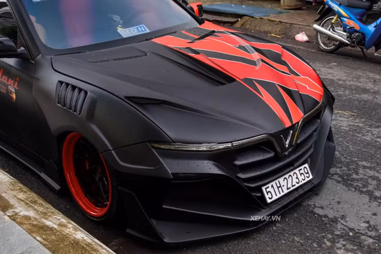 Đáng chú ý là bộ widebody này trông hầm hố với cụm đèn pha màu đỏ, mặt ca-lăng, cản trước hay nắp ca-pô có 2 cặp mắt màu đỏ đầy ma mị. Kính chiếu hậu cũng được tạo hình mới với phần ốp có tích hợp đèn viền LED. Phần vành xe được sơn màu đỏ cam, với đa chấu màu đen bóng.