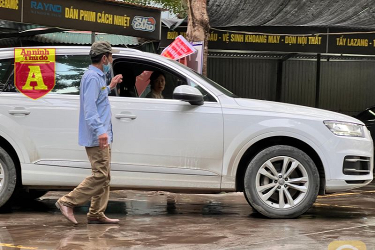 Bắt đầu từ ngày 21 tháng Chạp âm lịch, giá rửa xe ôtô tăng nhẹ, càng sát Tết thì giá càng cao. (Trong ảnh: Người đàn ông làm nhiệm vụ đón, sắp xếp xe vào điểm rửa)