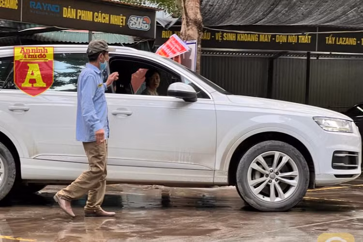 Bắt đầu từ ngày 21 tháng Chạp âm lịch, giá rửa xe ôtô tăng nhẹ, càng sát Tết thì giá càng cao. (Trong ảnh: Người đàn ông làm nhiệm vụ đón, sắp xếp xe vào điểm rửa)