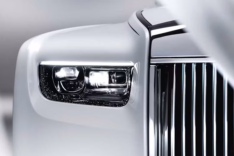 Nâng cấp quan trọng nhất ở Rolls-Royce Phantom 2023 mới chính là lưới tản nhiệt Phantheon phát sáng với đường nẹp ốp viền sáng bóng, trong khi đó các nan dọc của lưới tản nhiệt được thiết kế đặc biệt tạo cảm giác như đèn định vị trên mặt "đèn pha".