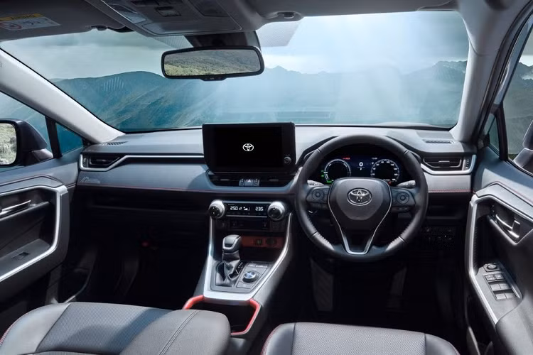 Bên trong Toyota RAV4 với gói phụ kiện Adventure Offroad Package II là chỉ khâu màu cam trên ghế, mặt táp-lô và tapi cửa. Thêm vào đó là viền màu cam bao quanh hộc đựng cốc trên bệ tì tay trung tâm và ngăn chứa đồ.