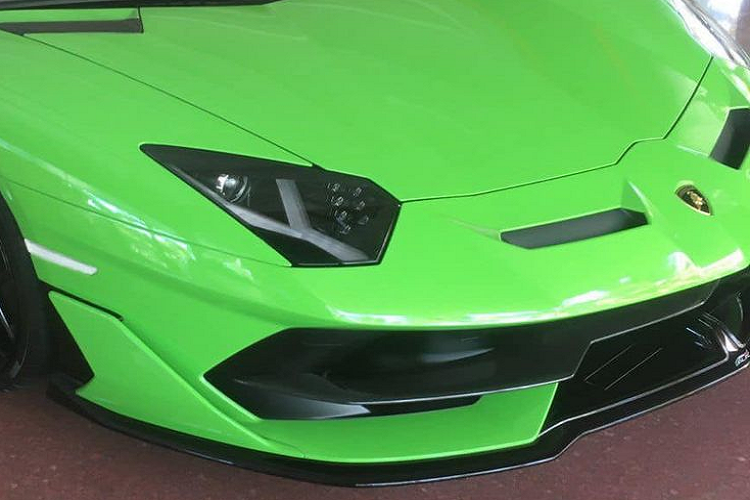 Lamborghini Aventador SVJ Roadster gây ấn tượng với phần đầu xe thiết kế mạnh mẽ với nhiều đường cắt xẻ táo bạo cùng loạt vây, khe gió để tăng hiệu quả động lực học. Khi nhìn từ đầu xe, nổi bật là cụm đèn pha góc cạnh cùng với dải đèn LED bắt mắt với những chiếc bóng đèn nhỏ bên trong.