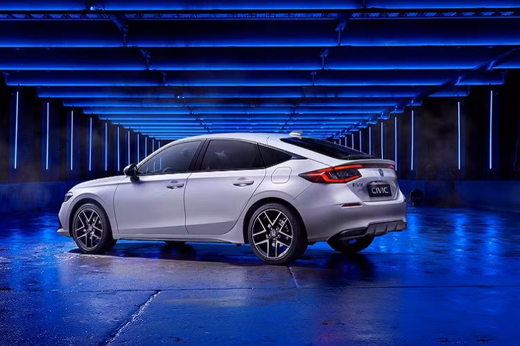 Bên sườn, Honda Civic Hatchback 2022 cũng có đường chân kính hất lên ở cột C và nóc dốc về phía sau theo phong cách của Accord. Trong khi đó, thiết kế đằng sau xe lại khác biệt so với phiên bản sedan vì ngắn hơn 125 mm và đi kèm cụm đèn hậu LED, nối với nhau bằng đèn phanh thứ 3 ở giữa. Ngoài ra, Honda Civic Hatchback 2022 còn được bổ sung kính cửa sau rộng hơn nhằm tăng tầm nhìn cho người ngồi bên trong xe. Bên cạnh đó là 2 ống xả hình thang cỡ lớn và bộ khuếch tán gió màu đen. 