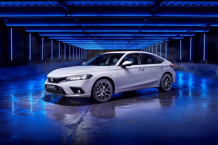 "Trái tim" của Honda Civic e:HEV Hatchback 2022 mới là hệ truyền động hybrid bao gồm máy xăng Atkinson Cycle 4 xi-lanh, dung tích 2.0L và 2 mô-tơ điện nằm trên cầu trước. Bên cạnh đó là cụm pin lithium-ion nhẹ hơn, nằm dưới ghế sau. 