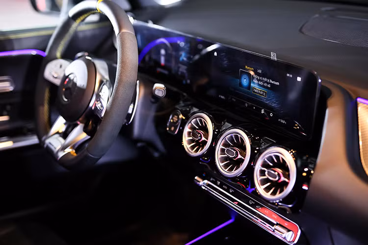 Cặp ghế trước của GLA 45 S 4MATIC+ được thiết kế thể thao, bọc da pha nỉ, hỗ trợ chỉnh điện và nhớ 3 vị trí tiện lợi. Vô-lăng được vát đáy AMG và bộ pedal kim loại.