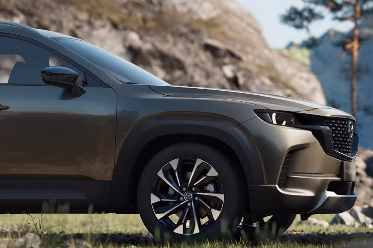 Vẫn được áp dụng ngôn ngữ thiết kế "Kodo" đặc trưng của thương hiệu Nhật Bản, Mazda CX-50 2023 mang trên mình lưới tản nhiệt màu đen ấn tượng. Viền dày dặn bao quanh lưới tản nhiệt cũng được sơn màu đen tương tự. Nối liền với lưới tản nhiệt là cụm đèn pha LED, tích hợp dải đèn LED định vị ban ngày.