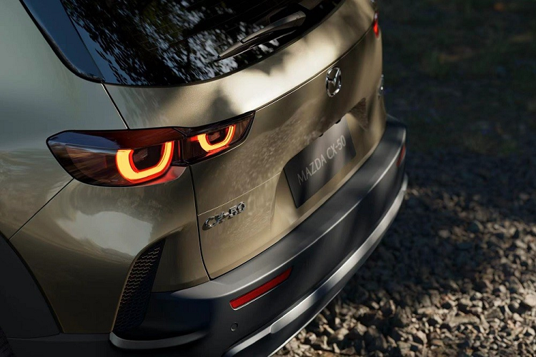 Khác với Mazda CX-5 2022, mẫu xe này không được trang bị đèn pha LED hình chữ nhật. Thay vào đó, đèn pha của Mazda CX-50 2023 có thiết kế tròn trịa hơn. Chưa hết, Mazda CX-50 2023 còn sở hữu cản trước rắn rỏi hơn CX-5, đi kèm 2 dải đèn sương mù nằm ngang cực mỏng, hốc gió trung tâm chia đôi và ốp màu bạc bên dưới.