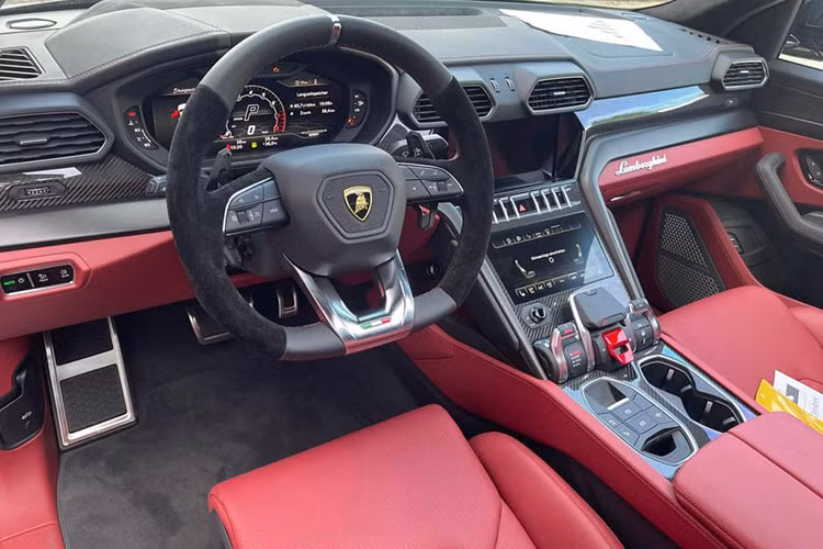 Khác với chiếc Lamborghini Urus màu đen của Dương Kon sử dụng tông màu đen chủ đạo trong cabin, chiếc Urus màu đen này có khoang nội thất nổi bật hơn nhờ tông màu đỏ chủ đạo kết hợp với màu đen. Chất liệu carbon xuất hiện ở táp-lô và bảng điều khiển.