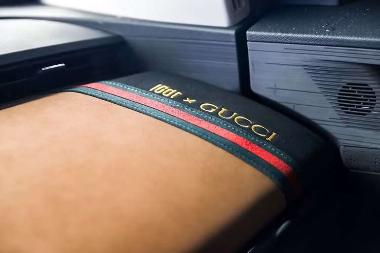 Tiếp đến là tay nắm cửa nằm chìm vào thân xe, bộ vành 16 inch với thiết kế 4 chấu kép, sơn 2 màu thể thao và các cột của xe đều được sơn màu đen, tạo hiệu ứng nóc trôi nổi. Bên dưới cửa còn có 4 vạch ngang màu đỏ, tương tự chi tiết trang trí cản trước. Đằng sau, Chery Unbounded Pro Gucci được trang bị cụm đèn hậu có thiết kế giống đèn pha và cánh gió mui tích hợp đèn phanh trên cao.