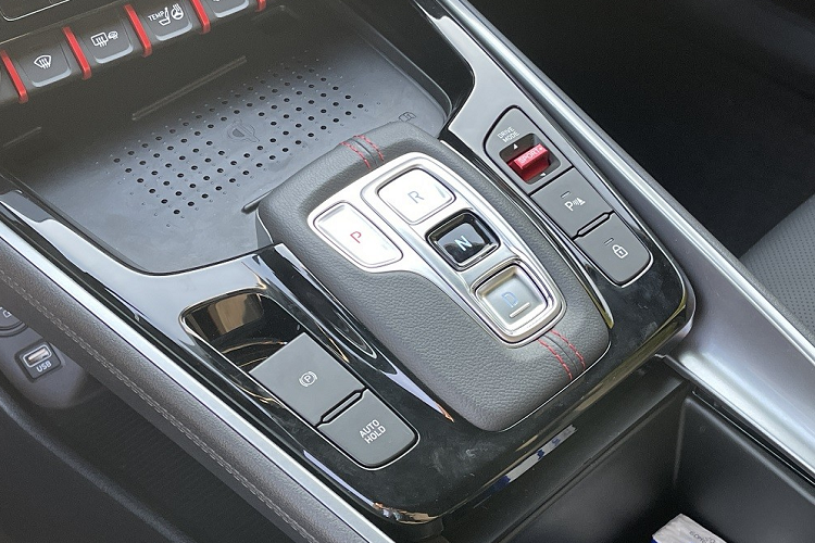 Bên dưới là sạc điện thoại thông minh không dây, các nút bấm chuyển số, phanh tay điện tử, tính năng tự động giữ phanh tạm thời và bộ bàn đạp bằng kim loại.