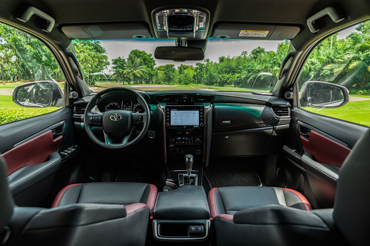 Bên trong Toyota Fortuner 2023 bản thấp nhất ở thị trường Malaysia xuất hiện bảng đồng hồ Optitron với màn hình đa thông tin 4,2 inch, hệ thống âm thanh 6 loa, hệ thống điều hòa chỉnh tay, vô lăng đa chức năng, nút bấm khởi động máy, mở cửa không cần chìa khóa, 3 chế độ lái, nội thất bọc nỉ và ghế trước chỉnh tay.