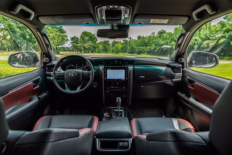 Bên trong Toyota Fortuner 2023 bản thấp nhất ở thị trường Malaysia xuất hiện bảng đồng hồ Optitron với màn hình đa thông tin 4,2 inch, hệ thống âm thanh 6 loa, hệ thống điều hòa chỉnh tay, vô lăng đa chức năng, nút bấm khởi động máy, mở cửa không cần chìa khóa, 3 chế độ lái, nội thất bọc nỉ và ghế trước chỉnh tay.