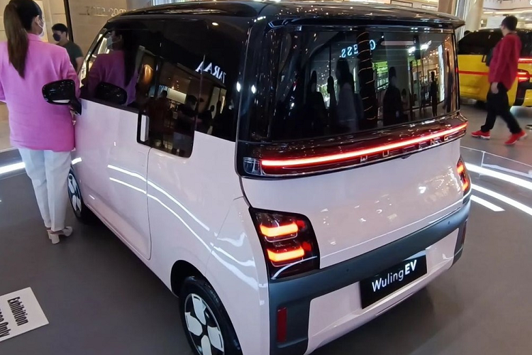 Bên dưới dải đèn LED định vị ban ngày là cổng sạc của xe với nắp tích hợp logo có thể phát sáng của thương hiệu Wuling. Tiếp đến là cụm đèn pha 2 bóng có kích thước khá lớn và được bao quanh bằng viền màu đen. Ngoài ra, xe còn có cản trước không sơn màu, tích hợp đèn sương mù và hốc gió trung tâm. Bên sườn, mẫu xe này chỉ có 2 cửa đồng thời được trang bị bộ vành có đường kính 12 inch, nằm trong lốp 145/70 R12 và đi kèm chụp la-zăng màu đen - trắng.