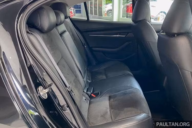 Ở bên trong cabin, nếu các phiên bản thông thường có hệ thống ghế ngồi bọc vải thì chiếc Mazda3 2022 đặc biệt này sử dụng chất liệu da và da lộn nhằm mang đến cái nhìn cao cấp hơn. Cần số và một phần của vô lăng cũng được bọc chất liệu nói trên. Tựa đầu hàng ghế trước có biểu tượng MS, viết tắt Mazdasport.