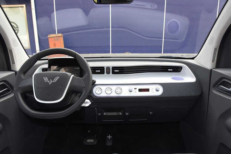 Tiếp đến là bảng đồng hồ kỹ thuật số, cửa gió điều hòa kéo dài trên mặt táp-lô, 3 núm xoay chỉnh điều hòa bên dưới và màn hình hiển thị thông tin khá nhỏ. Ở giữa hai ghế trước vẫn có núm xoay chuyển số hình tròn và phanh tay chỉnh cơ.