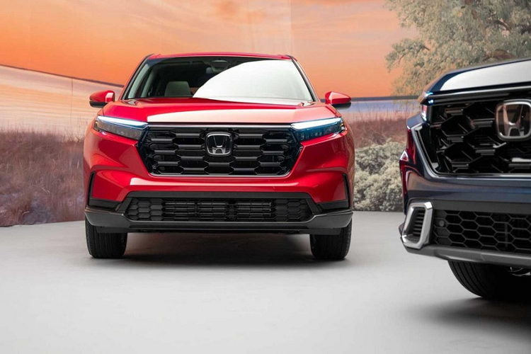 Không chỉ tăng kích thước, Honda CR-V 2023 còn được áp dụng phong cách thiết kế ngoại thất giống những mẫu xe cùng thương hiệu như Ridgeline và Passport TrailSport. Có thể thấy rõ điều này ở khu vực đầu xe với thiết kế táo bạo hơn trước. Trên đầu xe, Honda CR-V 2023 được trang bị lưới tản nhiệt hình lục giác mới với thiết kế thẳng đứng hơn và đi kèm mắt lưới tổ ong sơn màu đen. Ngay cả viền bao quanh lưới tản nhiệt cũng được sơn màu đen bóng.