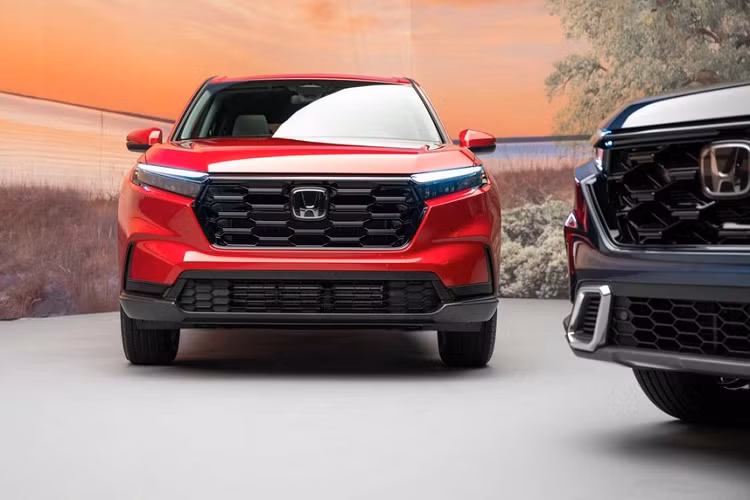 Không chỉ tăng kích thước, Honda CR-V 2023 còn được áp dụng phong cách thiết kế ngoại thất giống những mẫu xe cùng thương hiệu như Ridgeline và Passport TrailSport. Có thể thấy rõ điều này ở khu vực đầu xe với thiết kế táo bạo hơn trước. Trên đầu xe, Honda CR-V 2023 được trang bị lưới tản nhiệt hình lục giác mới với thiết kế thẳng đứng hơn và đi kèm mắt lưới tổ ong sơn màu đen. Ngay cả viền bao quanh lưới tản nhiệt cũng được sơn màu đen bóng.