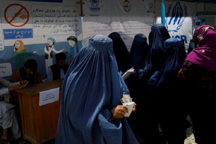 Một phụ nữ Afghanistan nhận tiền hỗ trợ từ 1 tổ chức từ thiện 