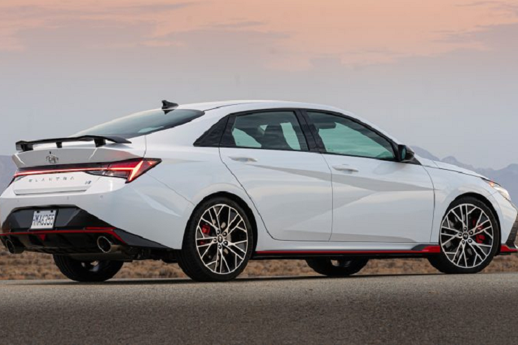 Phần đầu xe nổi bật với lưới tản nhiệt cỡ lớn, nối liền là cụm đèn pha LED sắc sảo. Nhìn từ phía sau, Elantra 2023 có cụm đèn hậu LED trải dài, trang bị cánh lướt gió thể thao. Xét về kích thước, so với thế hệ cũ, Hyundai Elantra 2023 thế hệ mới dài hơn 56 mm, rộng hơn 25 mm và thấp hơn 20 mm. Chiều dài cơ sở tăng thêm 20 mm lên mức 2.720 mm.