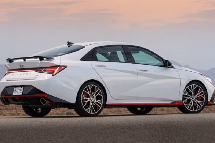 Phần đầu xe nổi bật với lưới tản nhiệt cỡ lớn, nối liền là cụm đèn pha LED sắc sảo. Nhìn từ phía sau, Elantra 2023 có cụm đèn hậu LED trải dài, trang bị cánh lướt gió thể thao. Xét về kích thước, so với thế hệ cũ, Hyundai Elantra 2023 thế hệ mới dài hơn 56 mm, rộng hơn 25 mm và thấp hơn 20 mm. Chiều dài cơ sở tăng thêm 20 mm lên mức 2.720 mm.