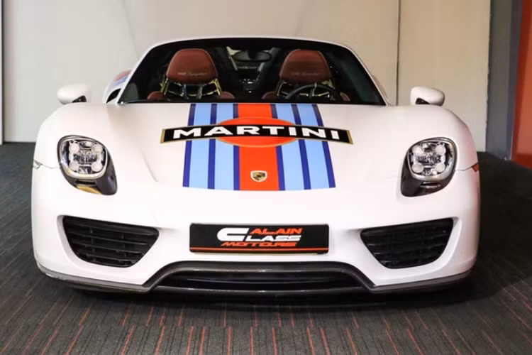 Việt Nam hiện chỉ có 2 chiếc siêu xe Porsche 918 Spyder, và không có chiếc nào giống với chiếc xuất hiện cạnh đại gia Hoàng Kim Khánh. Cụ thể, xe có ngoại thất màu trắng kèm tem Martini Racing độc đáo - chi tiết từng có trên nhiều dòng xe đua của Porsche.