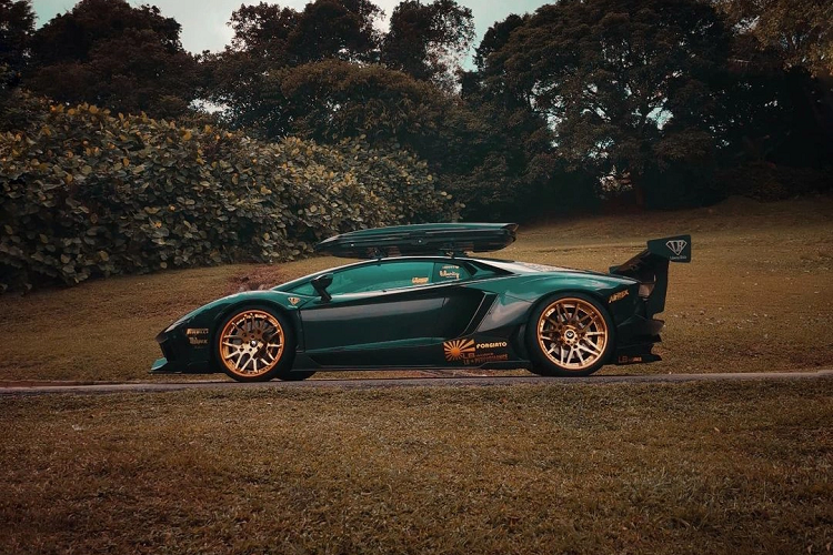 Mới đây, một chiếc Lamborghini Aventador độ Liberty Walk độc đáo đã trở thành chủ đề được bàn tán khá nhiều trên mạng xã hội. Ngoại thất của xe nổi bật với màu sơn xám, kết hợp với bộ mâm Forgiato màu vàng đồng khá nổi bật, đi kèm với đó là việc được trang bị hộp để đồ trên nóc xe, vốn xuất hiện khá ít trên những mẫu siêu xe.