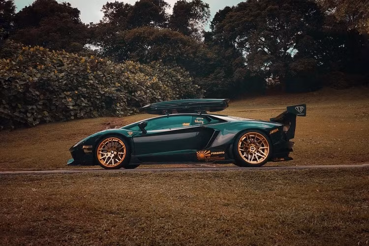 Mới đây, một chiếc Lamborghini Aventador độ Liberty Walk độc đáo đã trở thành chủ đề được bàn tán khá nhiều trên mạng xã hội. Ngoại thất của xe nổi bật với màu sơn xám, kết hợp với bộ mâm Forgiato màu vàng đồng khá nổi bật, đi kèm với đó là việc được trang bị hộp để đồ trên nóc xe, vốn xuất hiện khá ít trên những mẫu siêu xe.