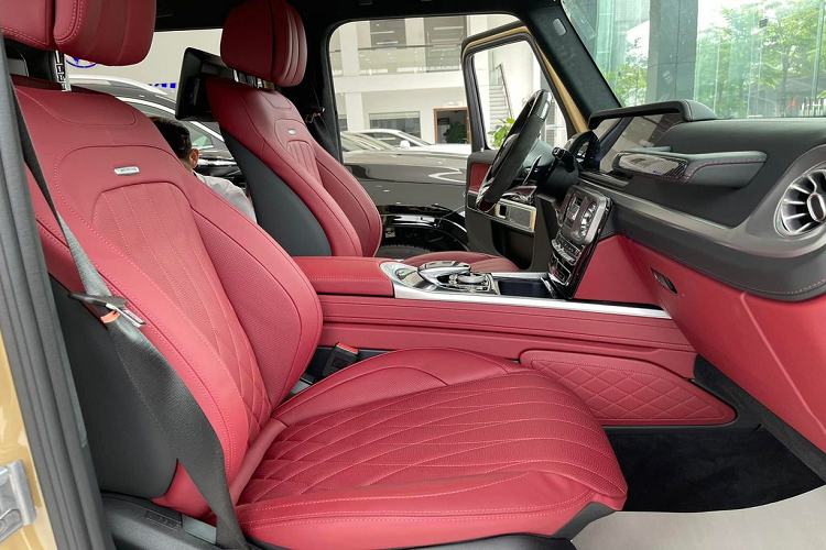 Ở bên trong cabin, Mercedes-AMG G63 có nội thất mang hai tông màu đỏ-đen tương phản với nhiều chi tiết sử dụng bằng chất liệu carbon. Xe sử dụng vô-lăng 3 chấu AMG vát đáy thể thao, được bọc da và ốp sợi carbon. Hai bên là cụm nút điều khiển giải trí, đàm thoại cũng như cài đặt Cruise Control. Phía sau vô-lăng vẫn là 2 lẫy chuyển số thể thao.