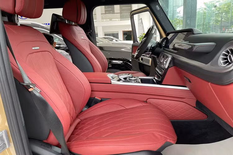 Ở bên trong cabin, Mercedes-AMG G63 có nội thất mang hai tông màu đỏ-đen tương phản với nhiều chi tiết sử dụng bằng chất liệu carbon. Xe sử dụng vô-lăng 3 chấu AMG vát đáy thể thao, được bọc da và ốp sợi carbon. Hai bên là cụm nút điều khiển giải trí, đàm thoại cũng như cài đặt Cruise Control. Phía sau vô-lăng vẫn là 2 lẫy chuyển số thể thao.