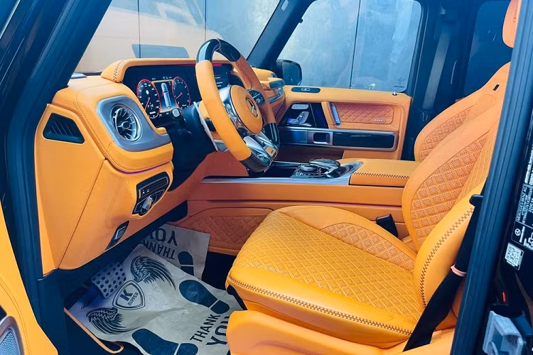 Tiến vào bên trong khoang lái của chiếc SUV hạng sang Brabus 800 Widestar mới về Phú Quốc định cư có nội y bọc da màu cam hết sức nổi bật cùng nhiều chi tiết được ốp carbon. Hàng ghế phía sau có thêm 2 màn hình giải trí lớn được gắn trên tựa đầu phía sau của hàng ghế trước. 