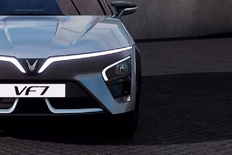 Cụm đèn pha chính của xe được đặt phía dưới và trang trí bằng dải đèn hình chữ "L". Ở giữa 2 hốc gió trung tâm của VinFast VF7 còn có hộp màu đen để đặt radar, phục vụ các tính năng an toàn chủ động ADAS. Vòng sang bên sườn, chúng ta sẽ bắt gặp bộ vành la-zăng có đường kính 21 inch với thiết kế 5 chấu khí động lực học.