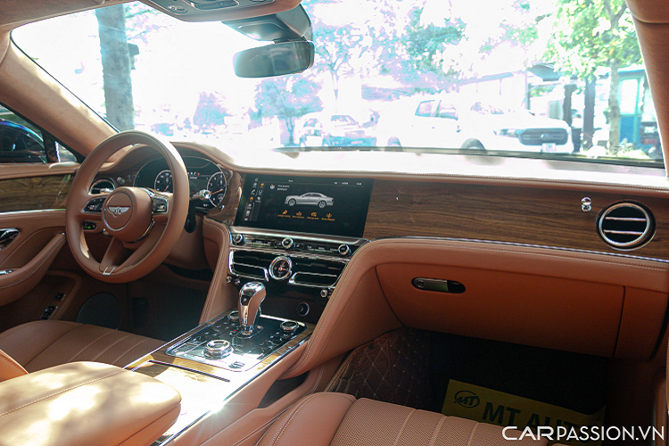 Nội thất Bentley Flying Spur V8 sang trọng với tông màu nâu, kết hợp với các chi tiết bằng da, gỗ và kim loại màu bạc. Bảng táp-lô được ốp gỗ Open Pore Koa. Vô lăng 3 chấu bọc da đồng màu nội thất tích hợp nhiều nút bấm hỗ trợ người lái.
