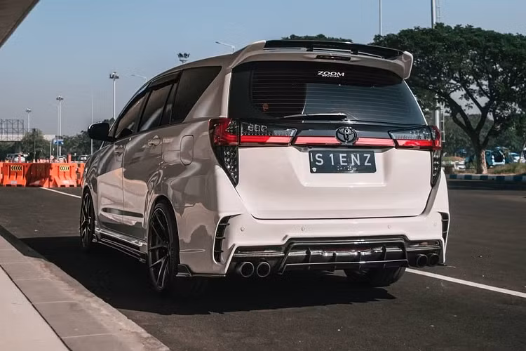 Bên dưới là hốc gió trung tâm cỡ lớn và 2 khe gió mới theo phong cách của siêu xe Lamborghini Urus. Ngoài ra, chiếc Toyota Innova độ này còn có dải đèn sương mù trước nằm hai bên hốc gió trung tâm. Vòng sang bên sườn, chúng ta sẽ thấy chiếc Toyota Innova độ này được bổ sung ốp hông mới và bộ vành Vorsteiner VFF101 R20 8.5/10.5, đi kèm lốp Michelin Pilot Super Sports 4S có kích thước 245/35/20 trước, 285/30/20 sau.