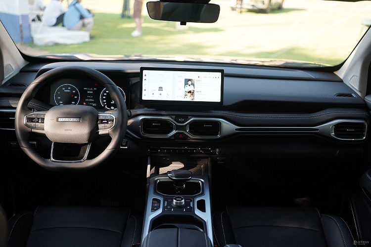 Bên dưới màn hình trung tâm là 2 cửa gió điều hòa với thiết kế như cặp kính. Cụm điều khiển trung tâm của Geely Radar RD6 được đặt ở vị trí khá cao, tạo thành vách ngăn giữa 2 ghế trước. Trên cụm điều khiển trung tâm xuất hiện sạc điện thoại thông minh không dây, cần số ngắn, núm xoay chọn chế độ lái, phanh tay điện tử và tính năng tự động giữ phanh tạm thời.